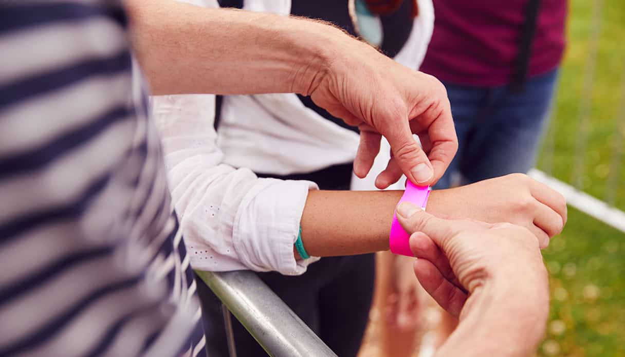 Am Eingang des Festivals bekommt eine Person ein rosa Armband, als Nachweis für den Zugang zum Festivalgelände.
