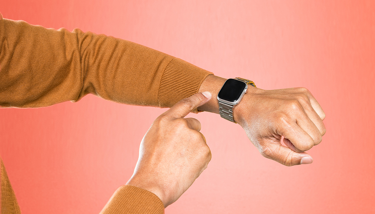 Dein Arm mit einer Apple Watch, der Hintergrund ist rosa.