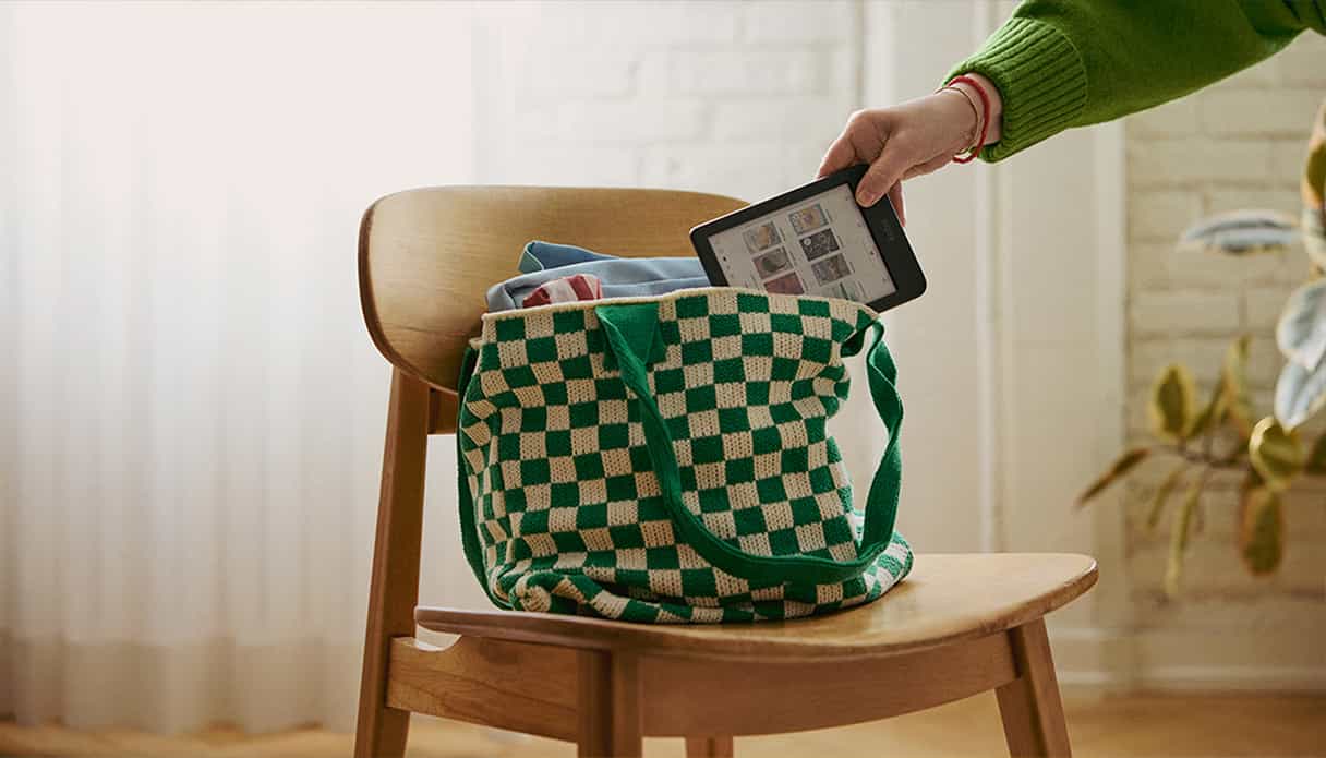 Ein E-Reader wird in eine karierte Tasche gesteckt.