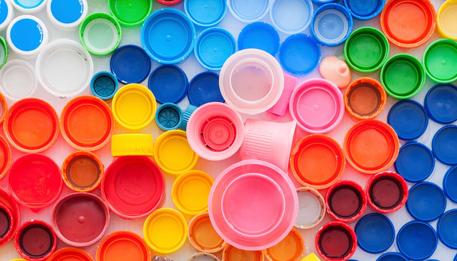 Ein Flatlay einer Sammlung von Plastikflaschenverschlüssen in verschiedenen Farben.