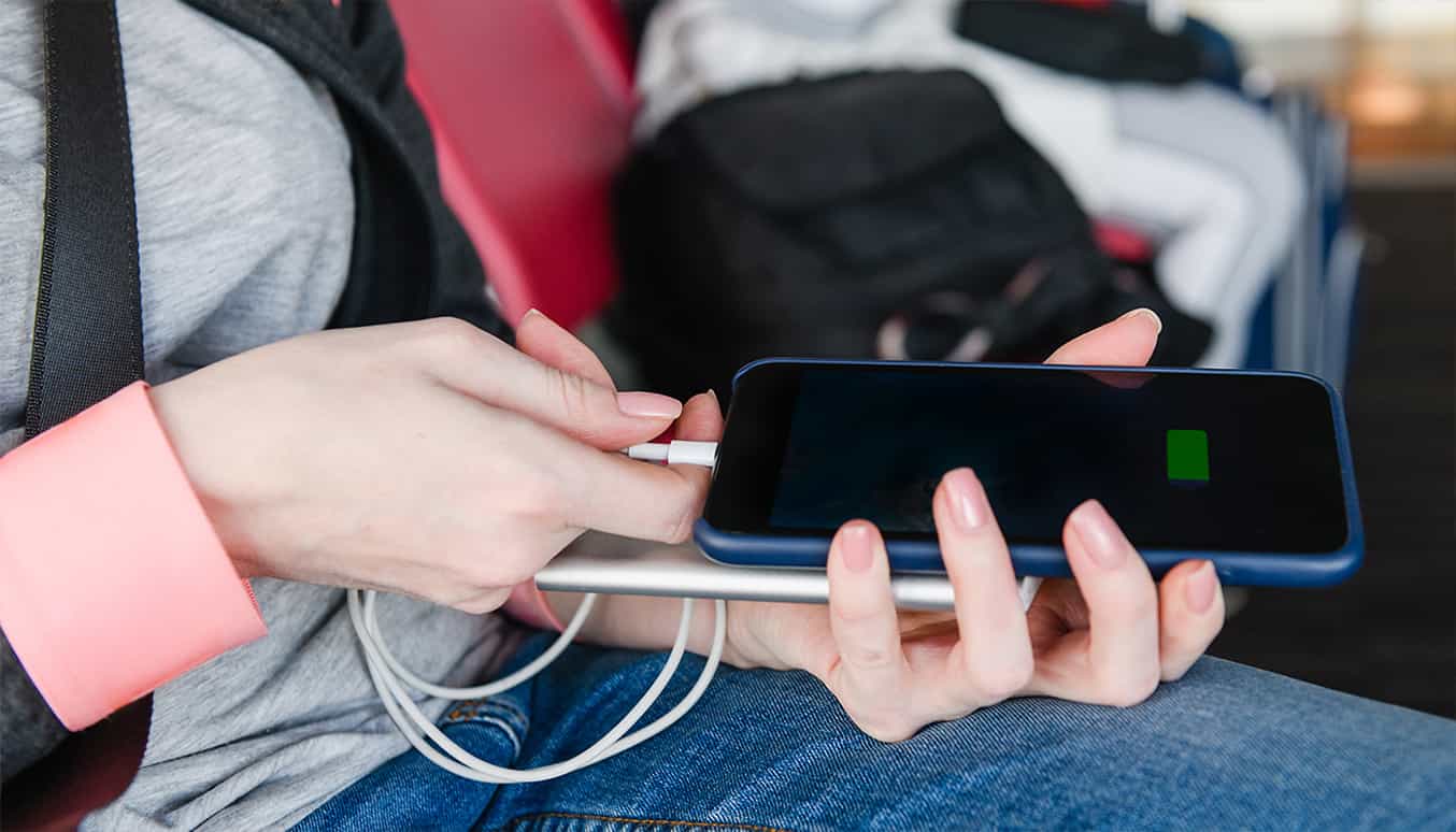 Eine knallorangefarbene Hintergrund mit einer auffällig grünen Powerbank und passendem Telefon.